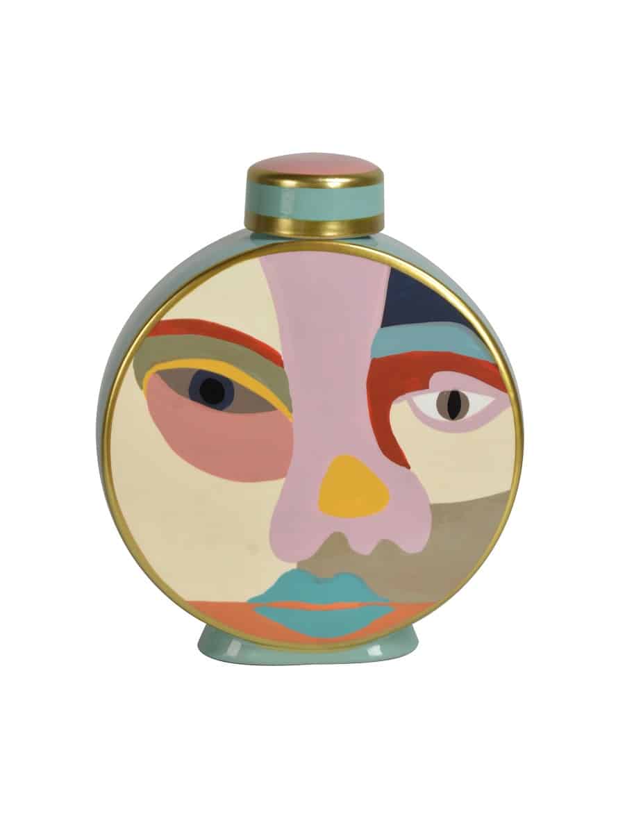 Flacon de parfum décoratif rond, style art abstrait, peint avec un visage aux couleurs vives, bordure dorée et bouchon rose/bleu sarcelle.