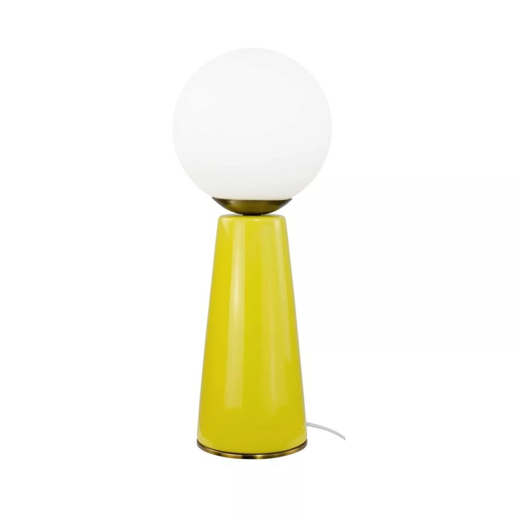 Lampe de table moderne avec base conique jaune vif, abat-jour globe blanc opalin et accents laiton/doré. Cordon électrique blanc visible.