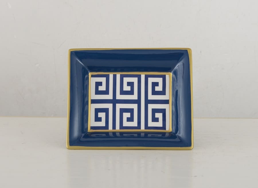 Plat décoratif rectangulaire bleu marine avec bordure dorée et motif grec clé blanc et bleu au centre, sur une surface blanche.