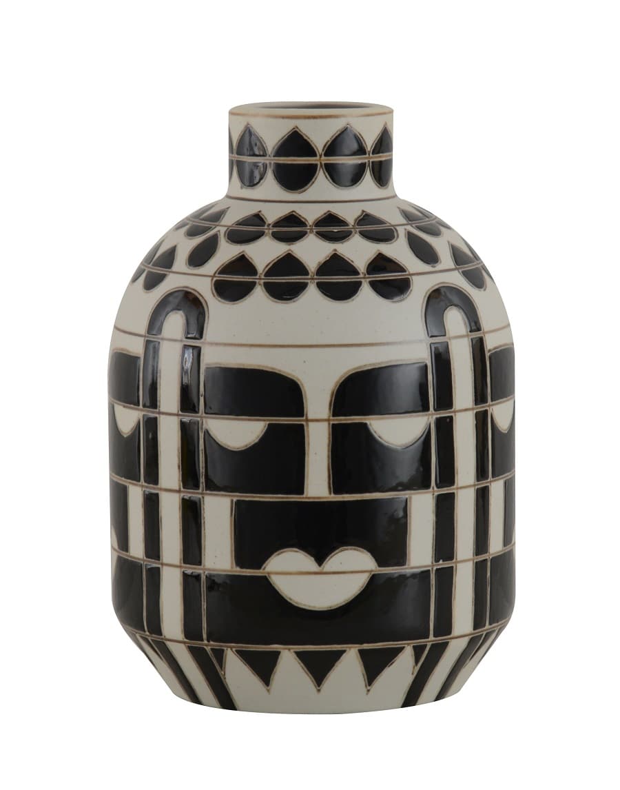 Vase en céramique style tribal noir et blanc avec motifs géométriques, évoquant un visage stylisé avec des yeux et une bouche.